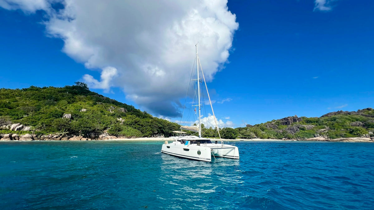 Modern cruising catamaran at anchor off a tropical island. Photo: Salome Papx, Unsplash